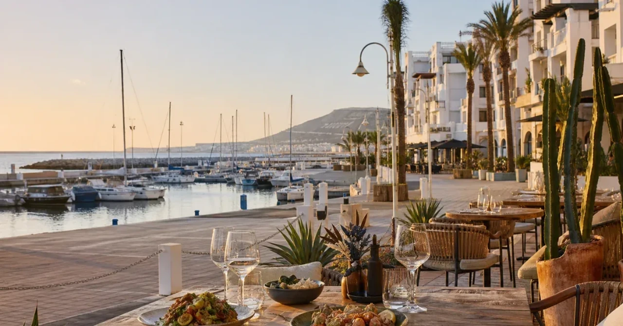 Luxury waterfront dining table along Agadir Marina overlooking yachts at sunset