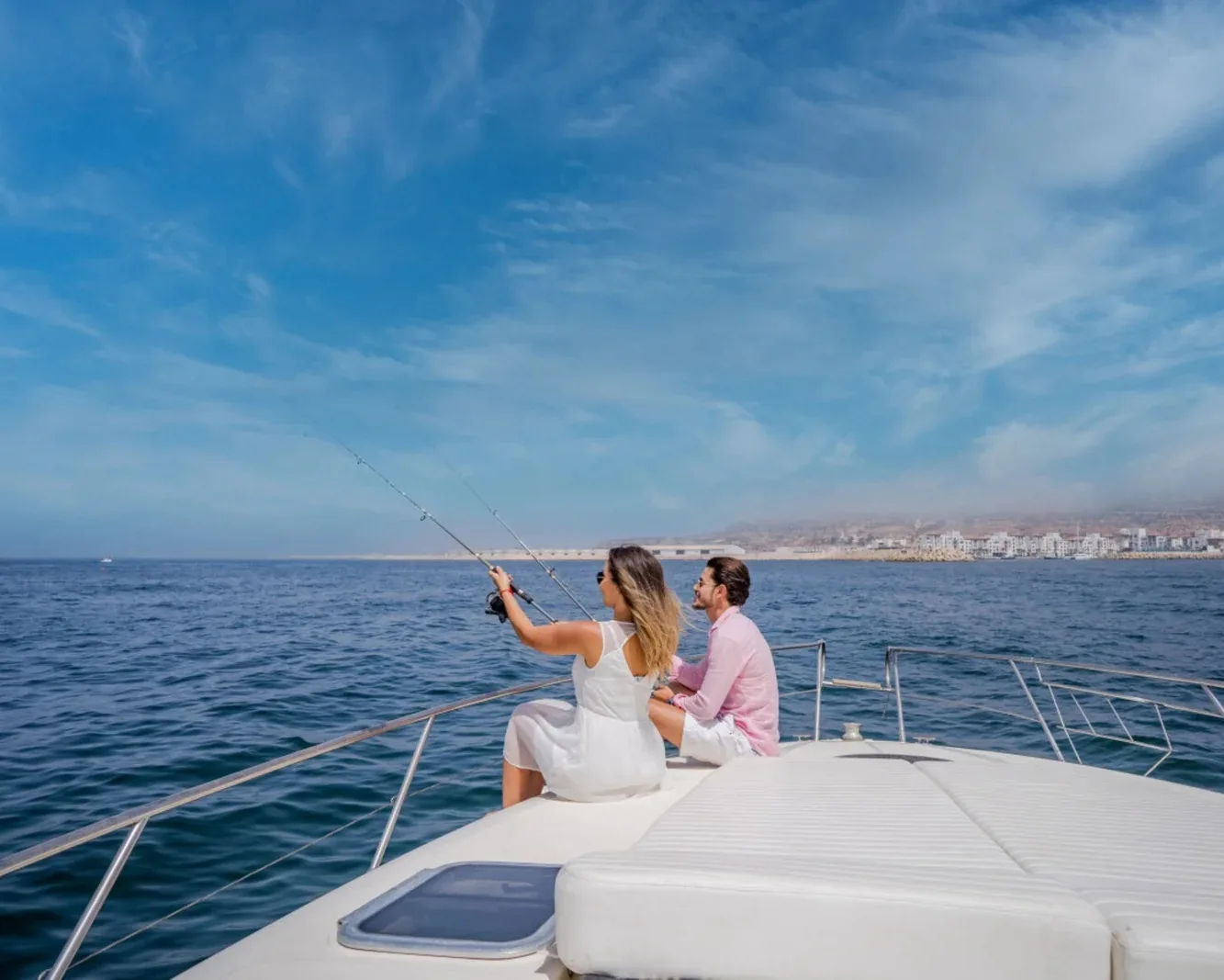 A couple fishing from a boat off the Agadir coast under a wide blue sky